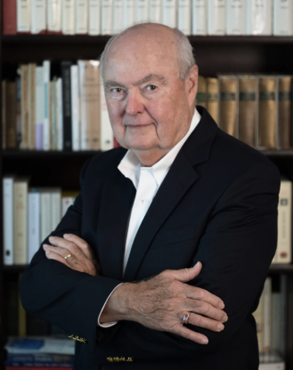 photo of man, bookshelves in background