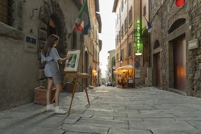 Student painting in an alley way in a European city