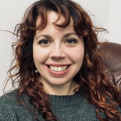 Jodie Lyon smiling at the camera, wearing a green sweater