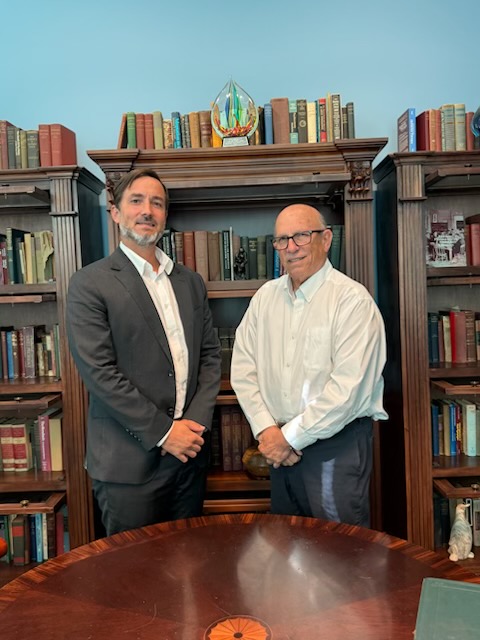 Nic and Tony Puente in front of book shelf