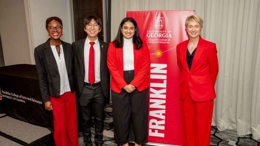 photo of four people with banner