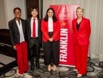 photo of four people with banner