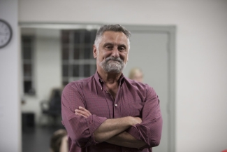 Photo of man indoors, arms folded