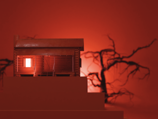 photo of house model bathed in red light, with spooky tree and shadows