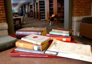 photo of books stacked on a table in a library 