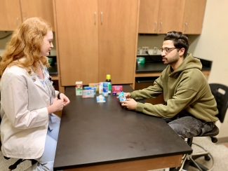 photo of two people at table with medicinal products