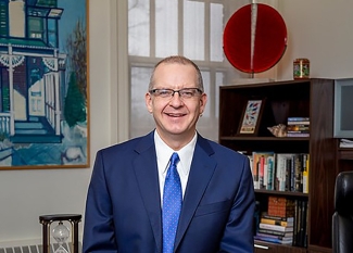 photo of man in office, with bookshelves, desk