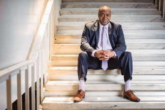 photo of man sitting on stairs in suit.