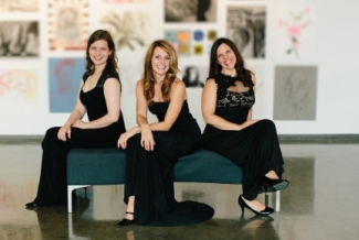 photo of three women on a bench, with paintings