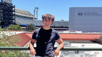 photo of man, stadium in background.