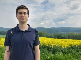 photo of man, field of yellow flowers in background