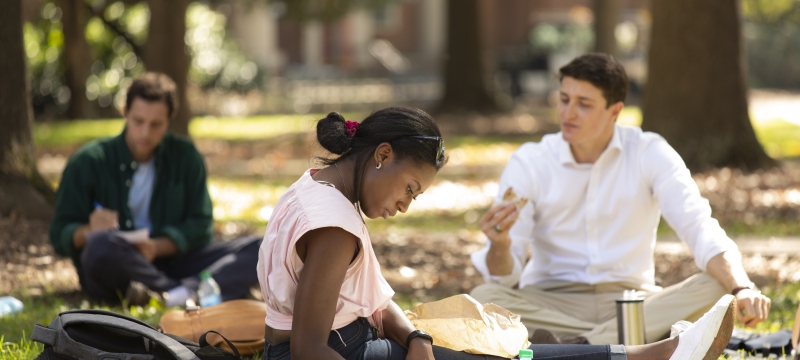 photo of three people on the quad lawn