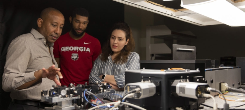 photo of three people with electronic equipment 