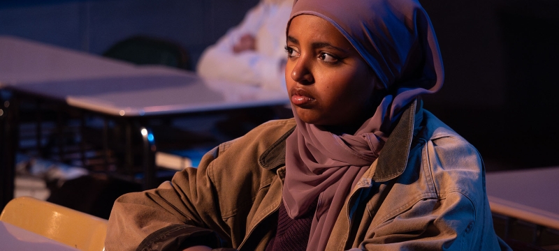 photo of woman, sitting at desk with book