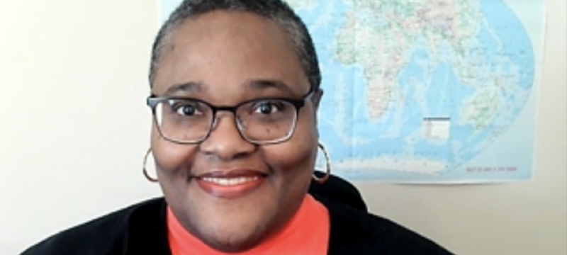 photo of woman, with wall map in background