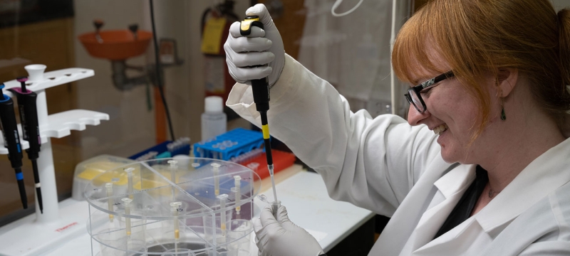 photo of woman with pipette and white coat