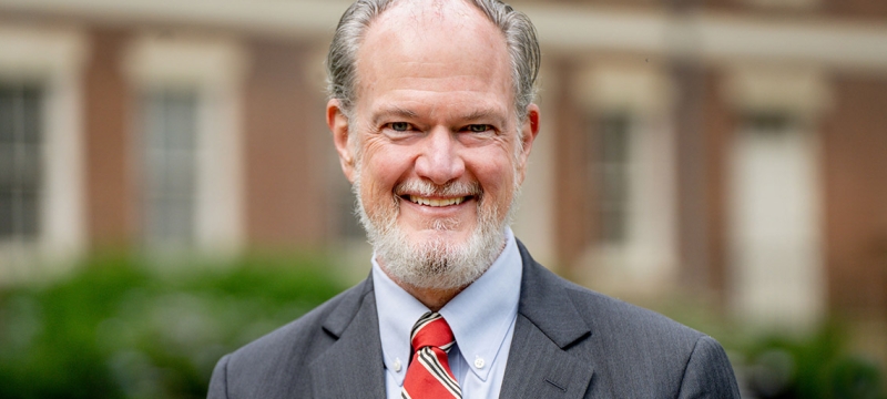photo of man, outdoors, building in background