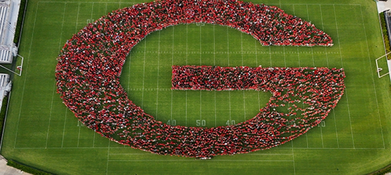 drone aerial photo of people making letter G in stadium