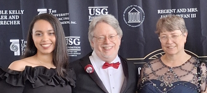 Photo of three people, with graphic backdrop