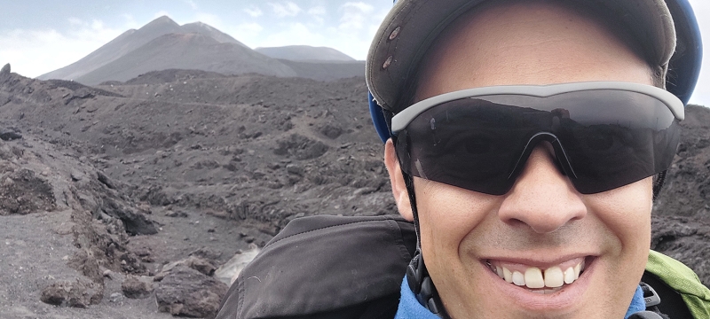 photo of man with volcanic mountain in background