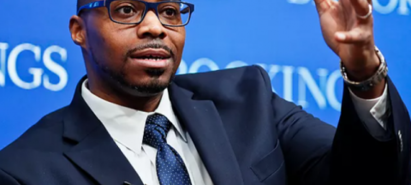 photo of man gesturing, blue background