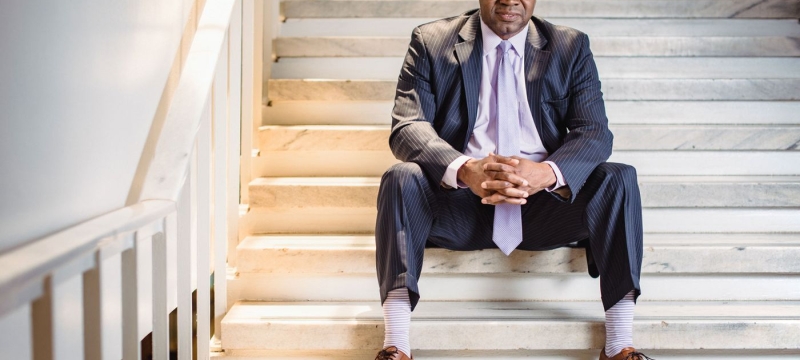photo of man sitting on stairs in suit.