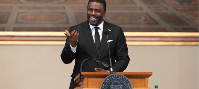 photo of man speaking at podium