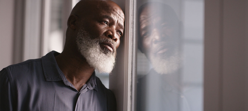 photo of man leaning against window 