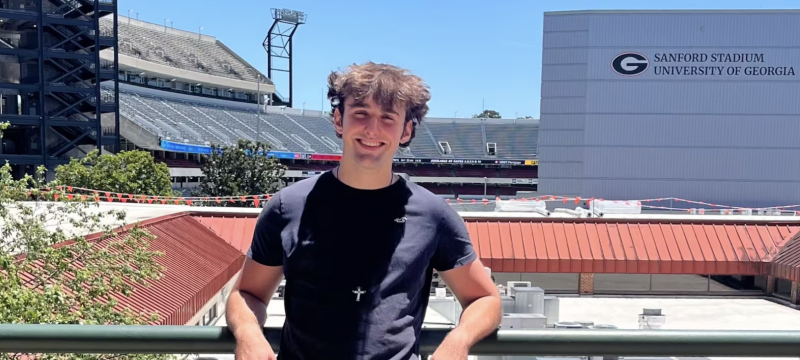 photo of man, stadium in background.