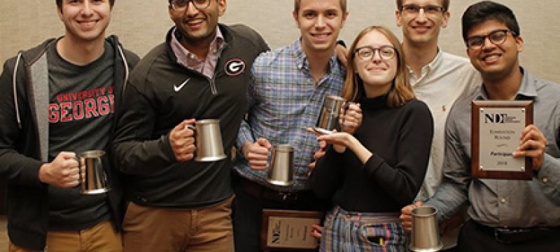 photo of six students holding award cups