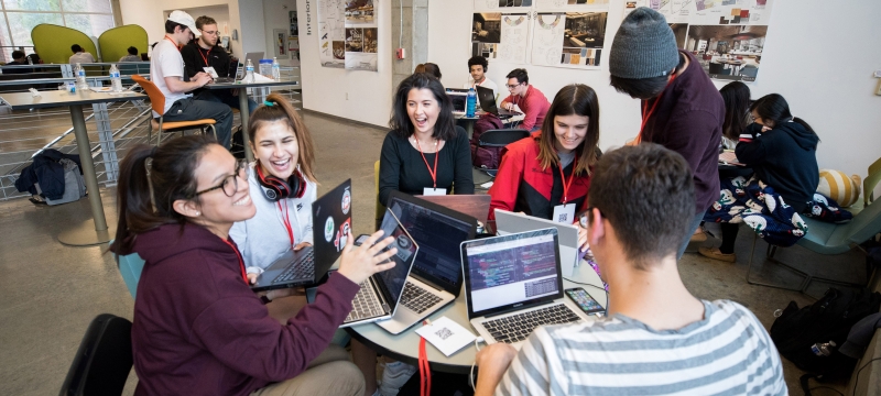photo of people around a table with laptop computers