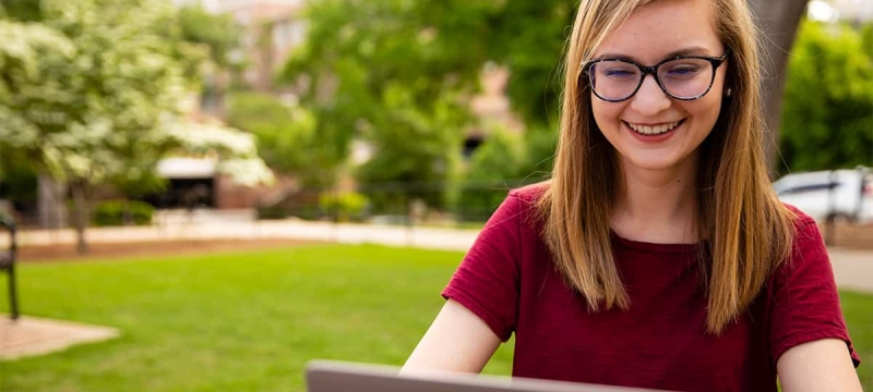 photo of woman outdoors with laptop computer