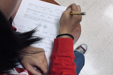 photo of person working match problems on paper with pencil