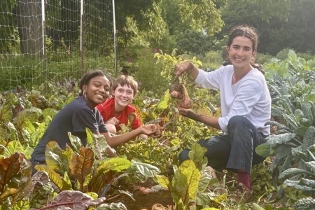 Maya Alandete and two students harvesting vegetables
