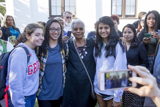 woman with students posing for photos