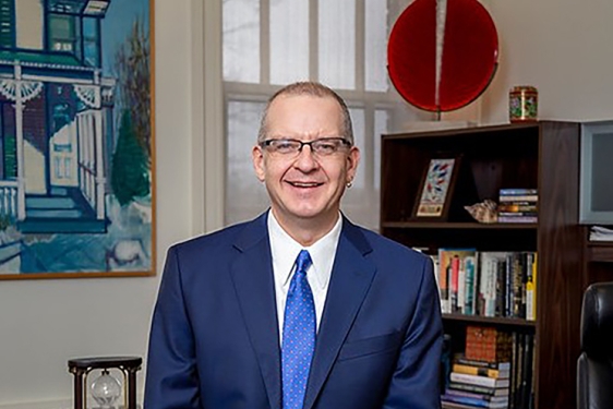 photo of man in office, with bookshelves, desk