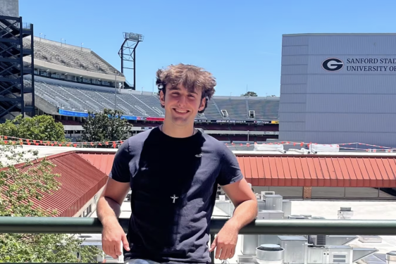 photo of man, stadium in background.