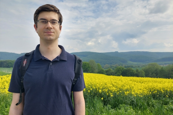 photo of man, field of yellow flowers in background