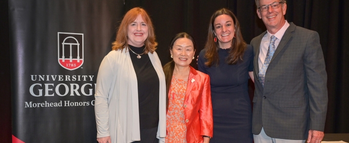 photo of four people, with banner